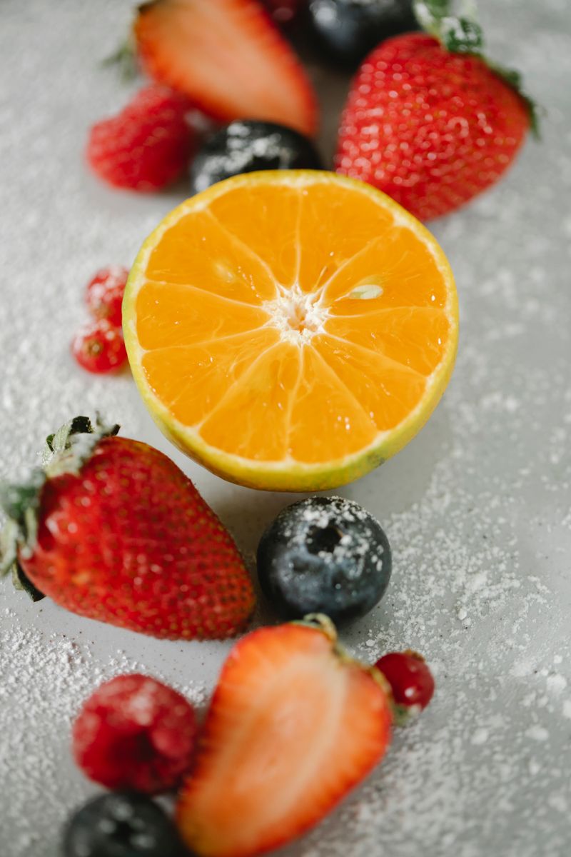 A picture of oranges, blueberries, and strawberries on a bed of ice