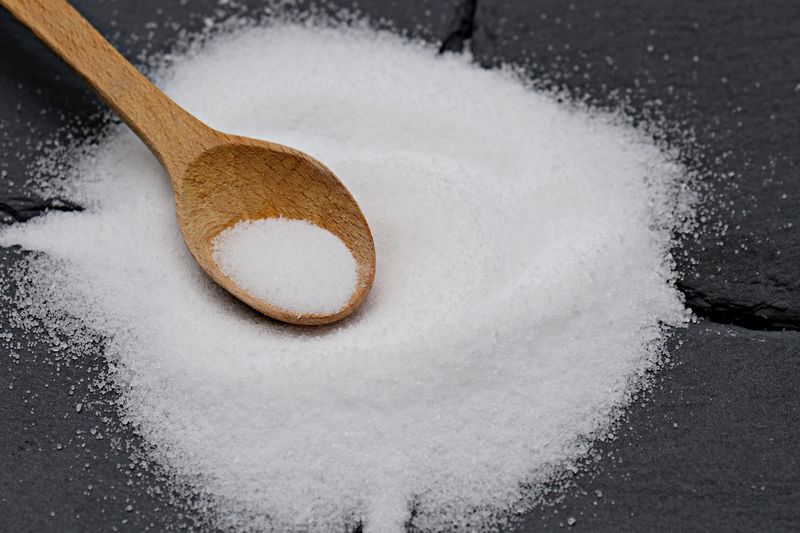 A picture of a wooden spoon filled with flavour enhancer powder