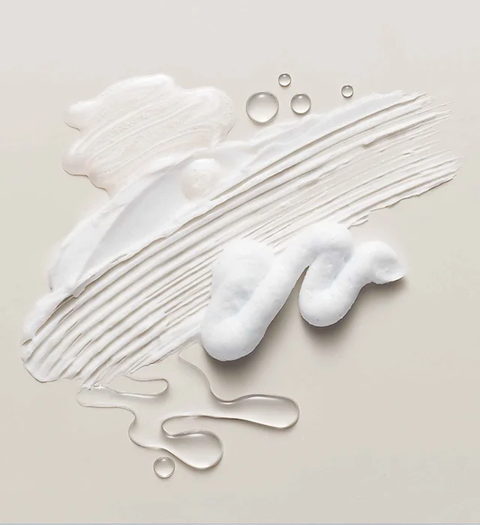 Splotches of white cream and liquids on a off-white canvas